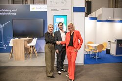Claudia Flörke, Felix Weiss (beide Light:Guard) und Bärbel Heidebroek (Landwind) besiegeln den Deal per Handschlag auf der WindEnergy Hamburg 2026<br />
© Landwind-Gruppe